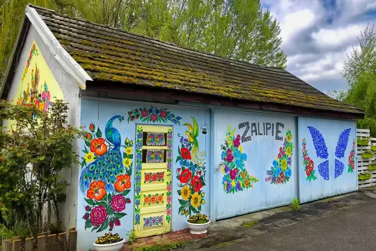 Kolorowy paw i kwiaty zdobią budynek w Zalipiu. Wspaniałe miejsce na zwiedzanie!